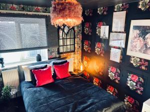 a bedroom with a blue bed with red pillows at The Cave House Canterbury with Hot Tub in Kent