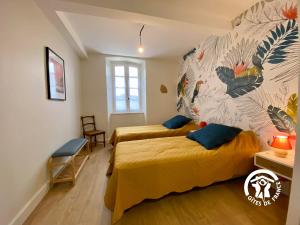 a bedroom with two beds and a mural on the wall at Le Mas de l'écluse in Caux-et-Sauzens