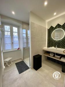 a bathroom with a shower and a sink and a mirror at Le Mas de l'écluse in Caux-et-Sauzens