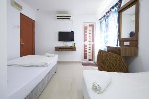 Camera bianca con 2 letti e una TV di U7 P Hotel a Kuala Lumpur