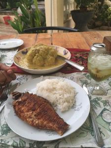 un plato de comida con arroz y carne en una mesa en B&B Verger Vannary, 