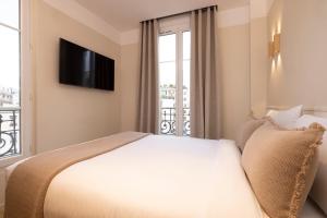 パリにあるHôtel Le Daumのベッドと窓が備わるホテルルーム