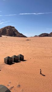 Una persona in piedi in mezzo al deserto di Wadi Rum Old Bedouin Camp a Wadi Rum