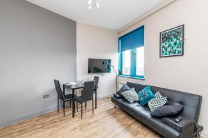 a living room with a couch and a table at Wigan Central Serviced Apartments in Wigan