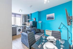 a blue living room with a couch and a table at Wigan Central Serviced Apartments in Wigan