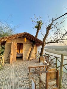 a house with a table and a tree on a deck at Happy Lemon Tree lodge in Sauraha