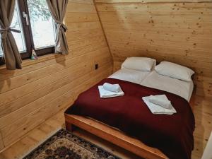 1 dormitorio con 1 cama con 2 toallas en Planinska kuća "Soko' Romanija", en Pale