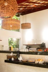 a kitchen with two pendant lights above a counter at Pousada Vila da Praia in Maricá