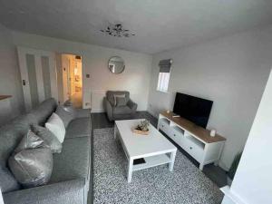 a living room with a couch and a tv at Alma Court Retreat Freshwater IOW in Freshwater
