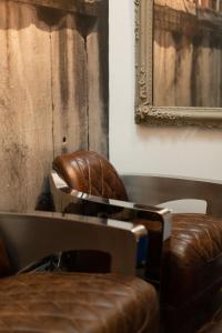 a leather chair sitting next to a table with a mirror at BDB Rooms Trastevere in Rome