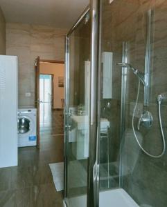 La salle de bains est pourvue d'une douche en verre et d'un lavabo. dans l'établissement Appartamento al Centro Storico di San Marino, à Saint-Marin