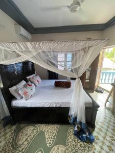 a bedroom with a bed with a canopy at Anayah House in Kiembi Samaki