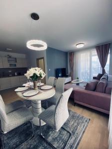 een woonkamer met een tafel en stoelen en een bank bij Apartment Lego in Mostar