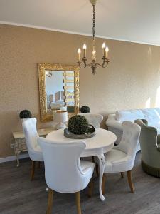 ein Esszimmer mit einem Tisch, Stühlen und einem Spiegel in der Unterkunft Studio-Apartment Shabby 47 Citynah, Retro & modern in Hamburg