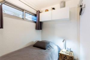sypialnia z łóżkiem i oknem w obiekcie Chez Claude - Joli studio cabine climatisé avec parking et piscine w mieście La Grande-Motte +13 zdjęć