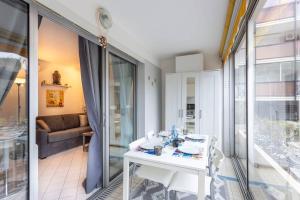 Biały stół i krzesła w pokoju z przesuwnymi szklanymi drzwiami w obiekcie Chez Claude - Joli studio cabine climatisé avec parking et piscine w mieście La Grande-Motte