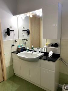 ein Bad mit einem Waschbecken und einem Spiegel in der Unterkunft Casa vacanza Veronica con giardino in Verbania