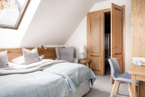 a bedroom with a bed and a desk and chairs at W Dolinie Tylicza in Krynica Zdrój