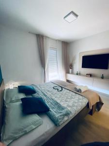 1 dormitorio con 1 cama grande con almohadas azules en Apartment Lego, en Mostar