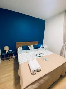 Un dormitorio azul con una cama con toallas. en Apartment Lego, en Mostar