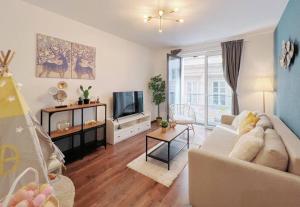 ein Wohnzimmer mit einem Sofa und einem TV in der Unterkunft Erkel Fairy Home in Budapest