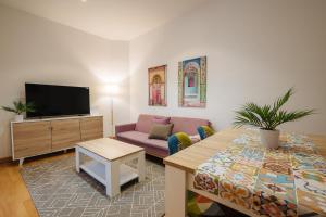 ein Wohnzimmer mit einem Sofa und einem Tisch in der Unterkunft Apartamento exclusivo junto a la catedral de Sevilla in Sevilla