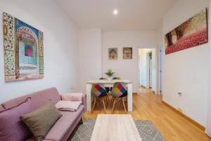 ein Wohnzimmer mit einem lila Sofa und einem Tisch in der Unterkunft Apartamento exclusivo junto a la catedral de Sevilla in Sevilla