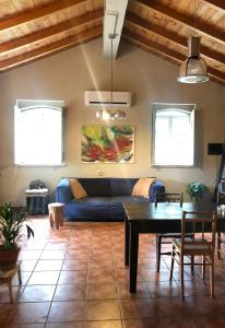 a living room with a blue couch and a table at Lovely quinta in nature with pool - Tomar in Pero Calvo
