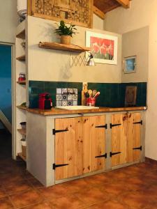 a kitchen with wooden cabinets and a counter top at Lovely quinta in nature with pool - Tomar in Pero Calvo