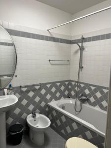 a bathroom with a sink and a tub and a toilet at Ormesini Apartment in Venice