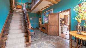 eine Treppe in einem Wohnzimmer mit blauen Wänden in der Unterkunft Kington Grange in Claverdon