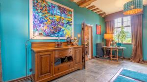 una sala de estar con paredes azules y una pintura en la pared en Kington Grange, en Claverdon