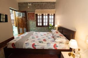 a bedroom with a bed with a comforter on it at Luho 25 Whitefield in Bangalore