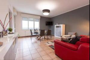 a living room with a red couch and a kitchen at G&G Apartment in Bologna