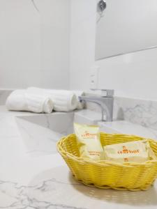 una cesta de papel higiénico sentada junto a un lavabo en Harbor Querência Hotel, en Cascavel