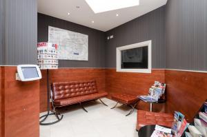 a waiting room with a bench and a tv at Wardonia Hotel in London