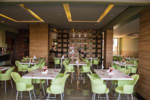 a dining room with tables and green chairs at Gelps Hotel in Rio Verde