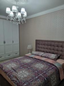 a bedroom with a large bed and a chandelier at Luxury Stefan cel mare Apartment in Chişinău +8 photos
