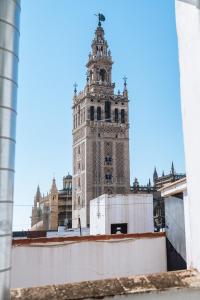 einen hohen Uhrenturm auf einem Gebäude in der Unterkunft Ático lujo junto a la catedral. Giralda in Sevilla