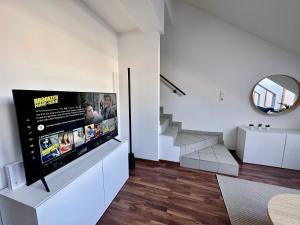 sala de estar con TV de pantalla plana en la pared en Designer Apartment im Herzen von Fulpmes, en Fulpmes