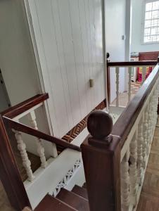 a staircase in a house with white railings at A Jewel of A Chalet in Roseau