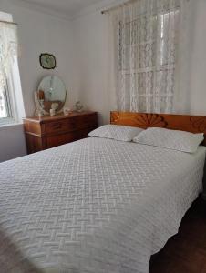 1 dormitorio con 1 cama con edredón blanco y ventana en A Jewel of A Chalet en Roseau