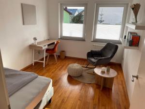 een slaapkamer met een bed, een bureau en een stoel bij Saarland Appartements Losheim-Rimlingen in Rimlingen