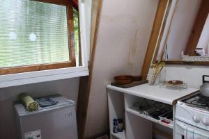 a small kitchen with a stove and a window at Refugio del Pollux- Coyhaique- Orillas Lago Pollux in Coihaique