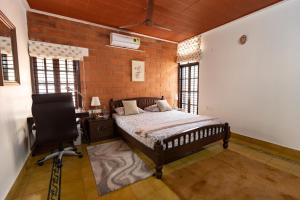 a bedroom with a bed and a desk and a chair at Luho 25 Whitefield in Bangalore