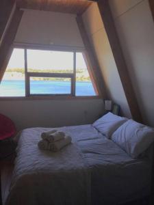 1 dormitorio con 1 cama con 2 toallas en Refugio del Pollux- Coyhaique- Orillas Lago Pollux, en Coyhaique