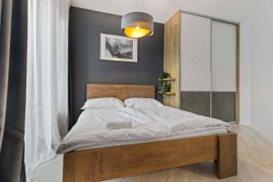 Schlafzimmer mit einem großen Bett mit einem Kopfteil aus Holz in der Unterkunft LAM Anthracite w AC & balcony in Bratislava