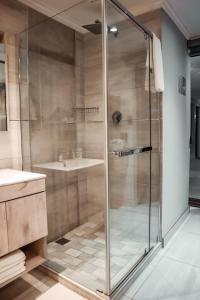 a glass shower in a bathroom with a sink at Cascades Guest Lodge in Nelspruit +71 photos