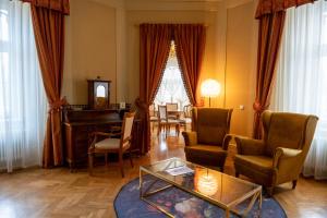 a living room with a grand piano and chairs at Pałac Wojanów in Wojanów