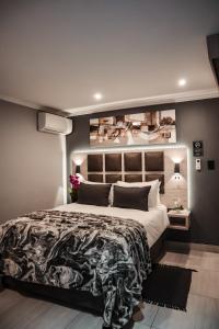 Un dormitorio con una cama grande y una pared con cuadros. en Cascades Guest Lodge en Nelspruit